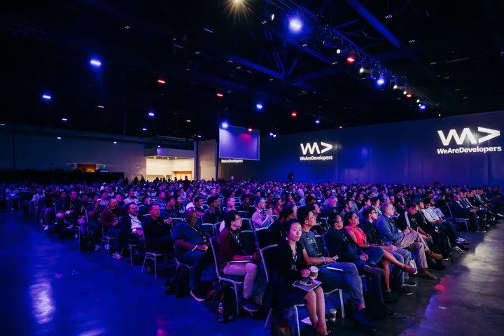 Audience seated in a blue-lit World Congress auditorium.