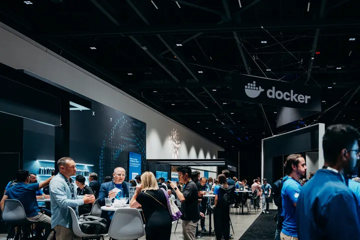 Attendees talk at the Docker booth on the World Congress expo floor.