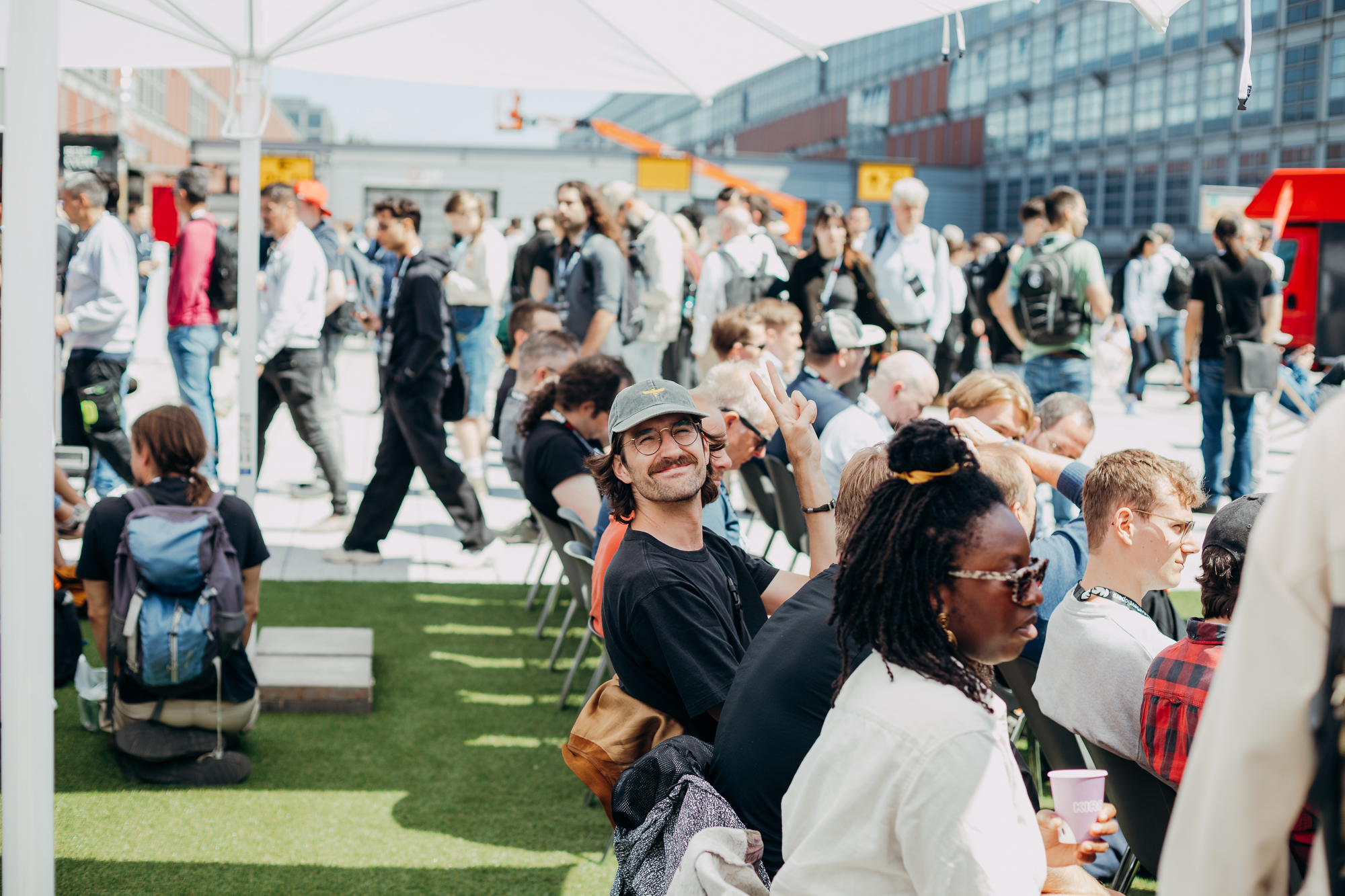 Developers meet and connect in an outdoor conference networking area.