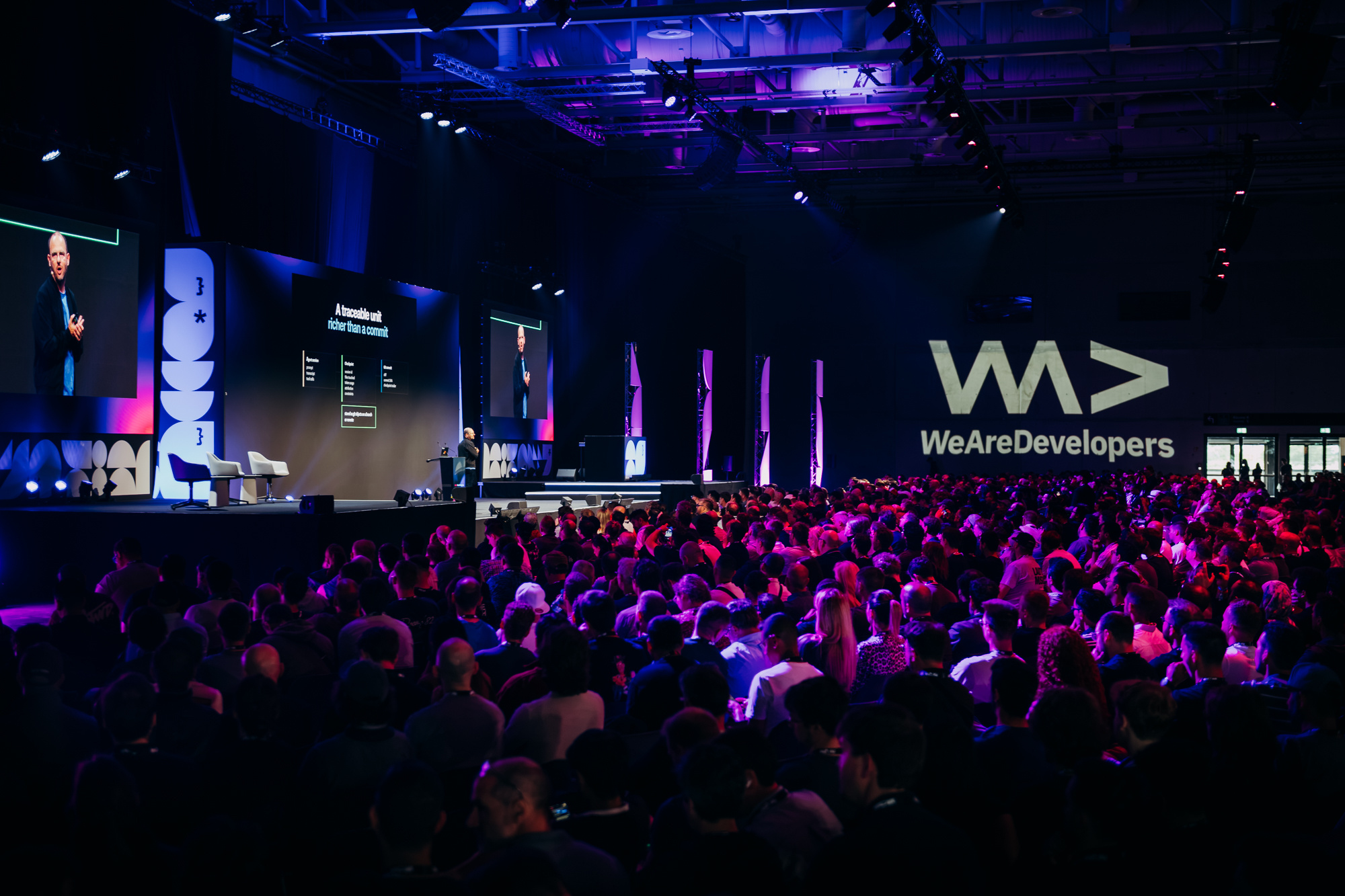 A speaker addresses the packed WeAreDevelopers Main Stage audience in San José.